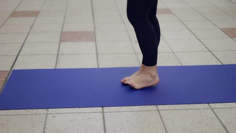 close up of a woman doing sports in outdoors passage place on yoga mat