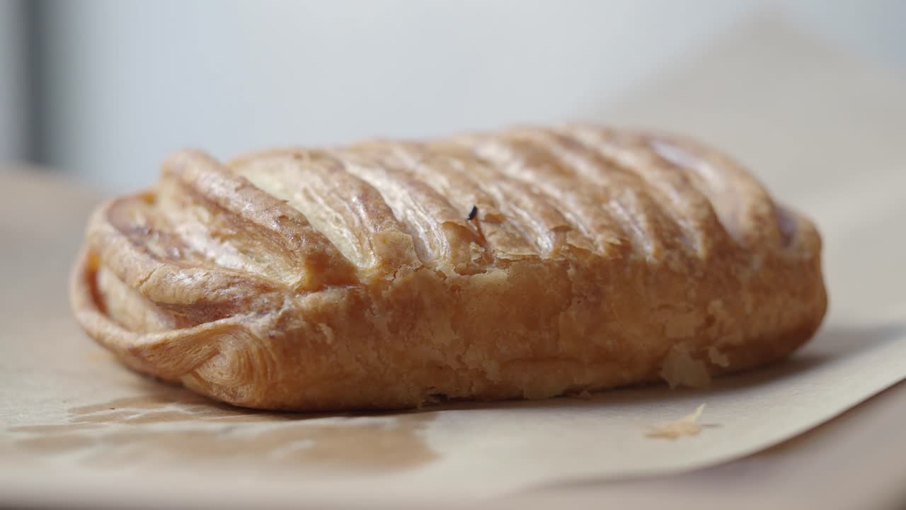 Mano che raccoglie un dolce dorato cotto dalla carta da forno