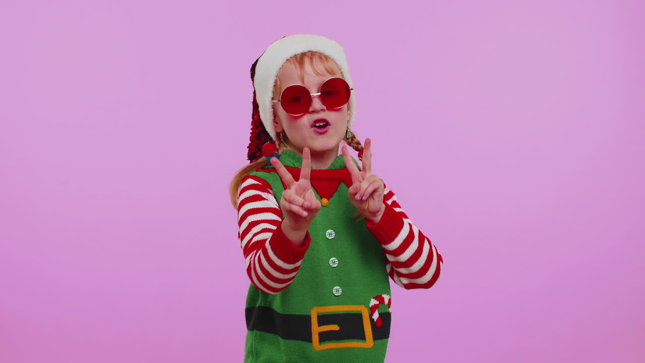 Dívka, vánoční skřítek Santa Clause, poslouchá hudbu přes sluchátka, tančí disko, blbne a baví se