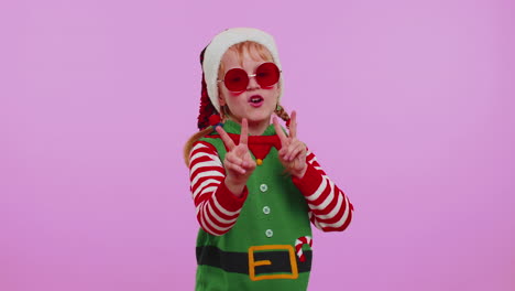 chica navidad papá noel duende escuchando música a través de auriculares bailando discoteca jugando divirtiéndose
