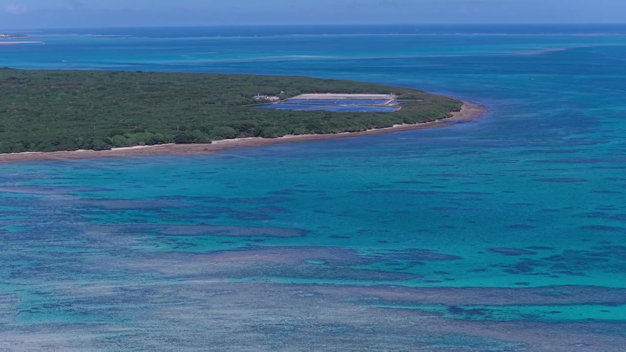 Riprese aeree orizzontali con lento movimento in avanti sopra l'impianto di allevamento di gamberi Euglena e la costa turchese dell'isola di Taketomi, Okinawa, Giappone.