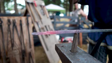 blacksmith hammering and forging a molten piece of metal