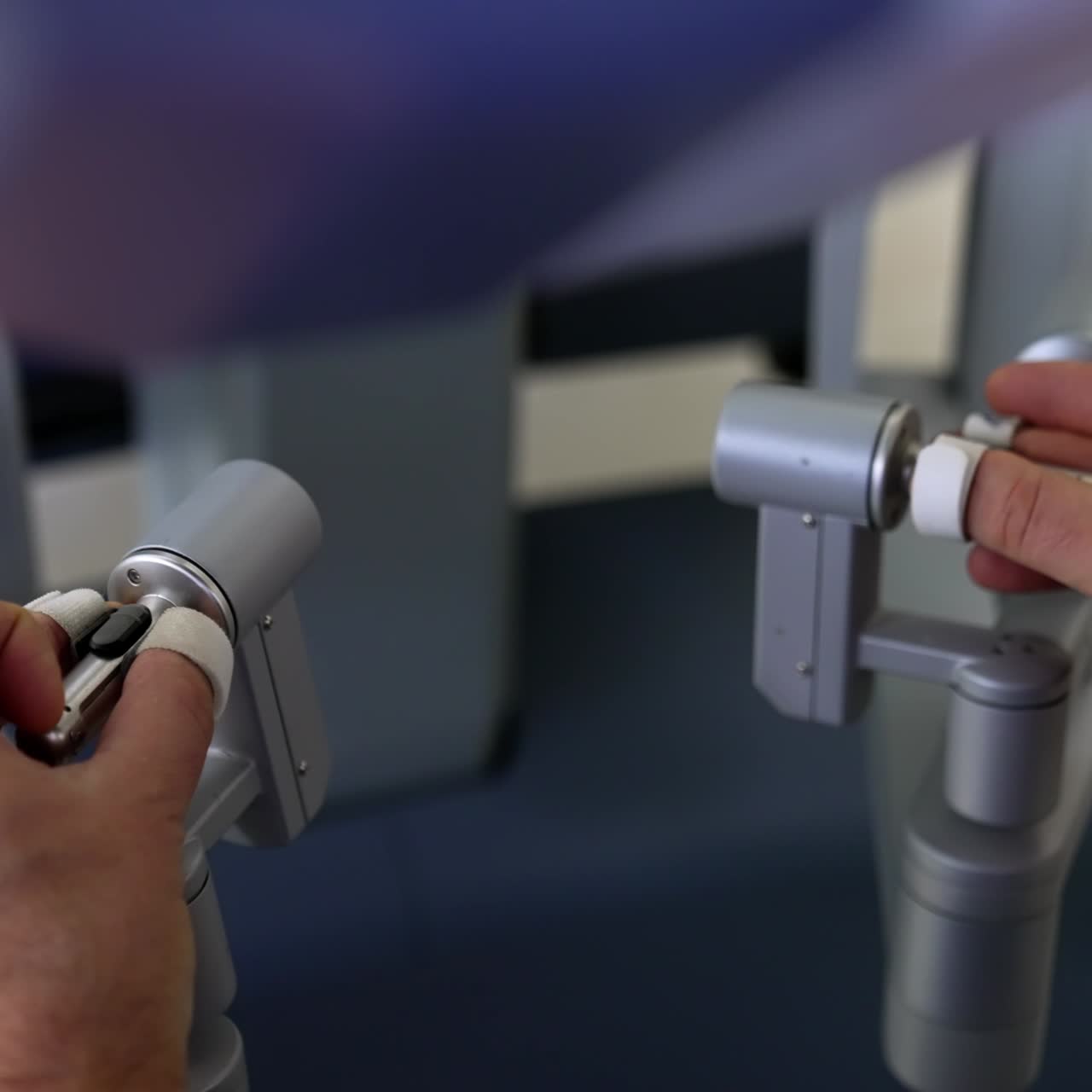 Hands of male main surgeon move the motion manipulators of robotic system. Surgical specialist operating advanced equipment to perform surgery. Close up