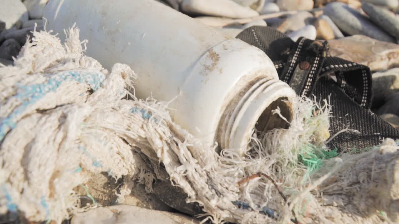 botella de plástico y basura en una playa