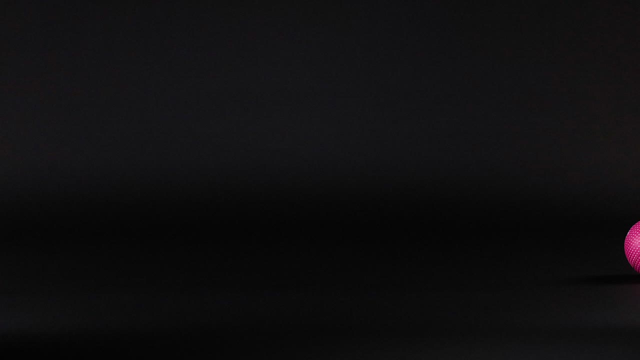 una pelota rosa se mueve a través de un fondo oscuro
