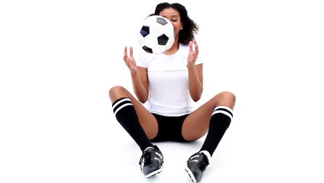 una chica bonita atando sus botas de fútbol.