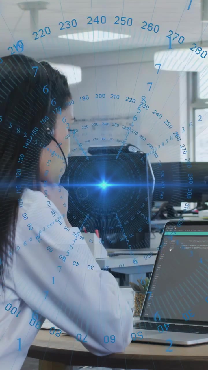 Video verticale: Donna con cuffie che testa codice mentre un HUD blu si anima e illumina un laptop.
