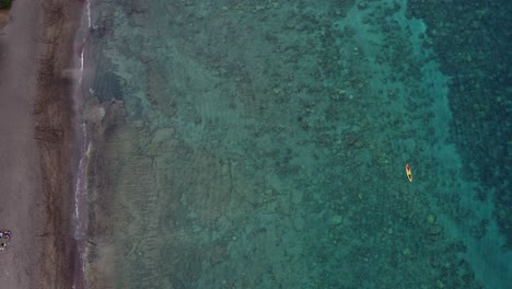 Aerial-drone-video-of-tourists-rowing-in-a-colorful-kayak-in-tropical-Hawaiian-exotic-destination-with-turquoise-calm-ocean-surface