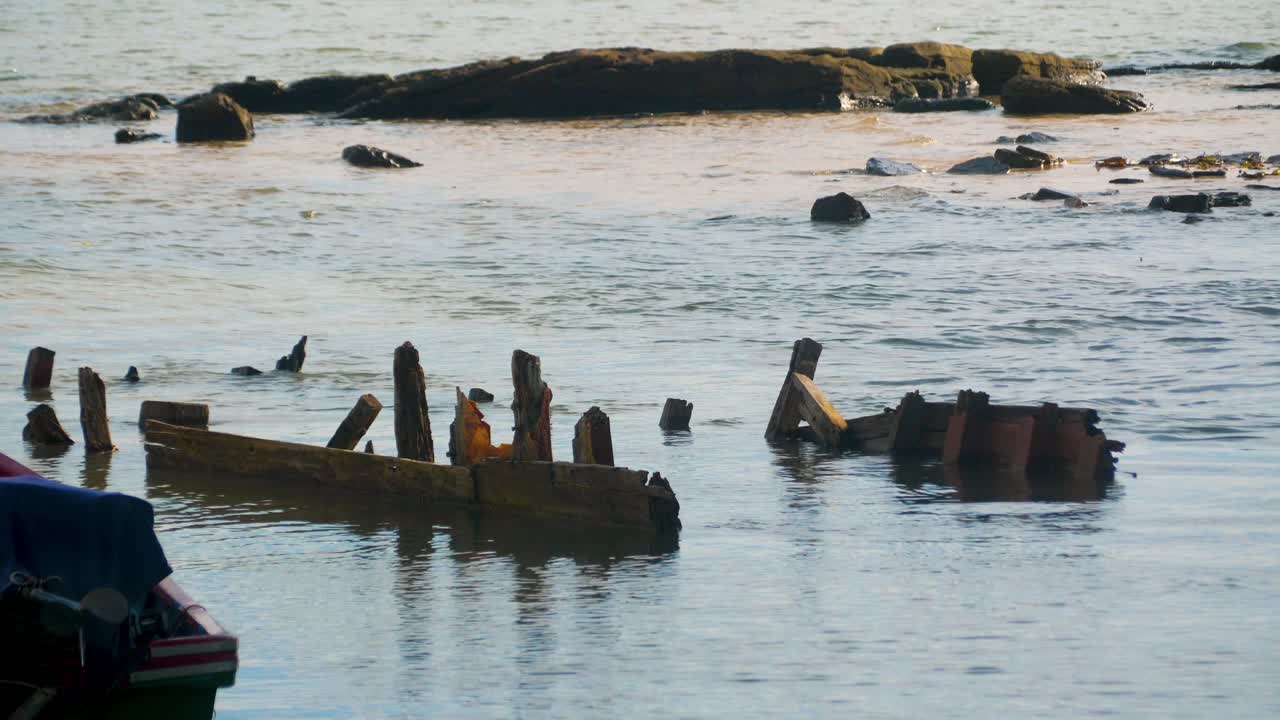 Old wood pier remains driftwood off the coast of Koh Rong Samloem island in Cambodia
