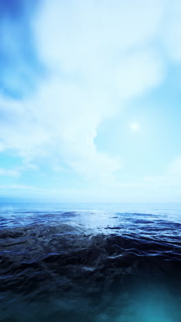 a tranquil scene of the ocean with blue skies and white clouds