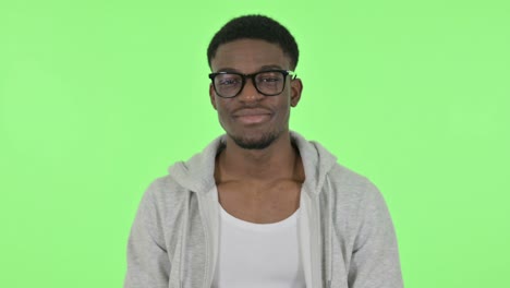african man smiling at camera on green background