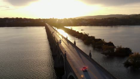 traffic driving on long historic bridge over susquehanna river between lancaster county and york county pa usa at sunset, sunrise