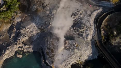 Beautiful-aerial-look-down-rising-of-nature-scene---Steaming-Pohutu-Geyser,-Rotorua,-New-Zealand