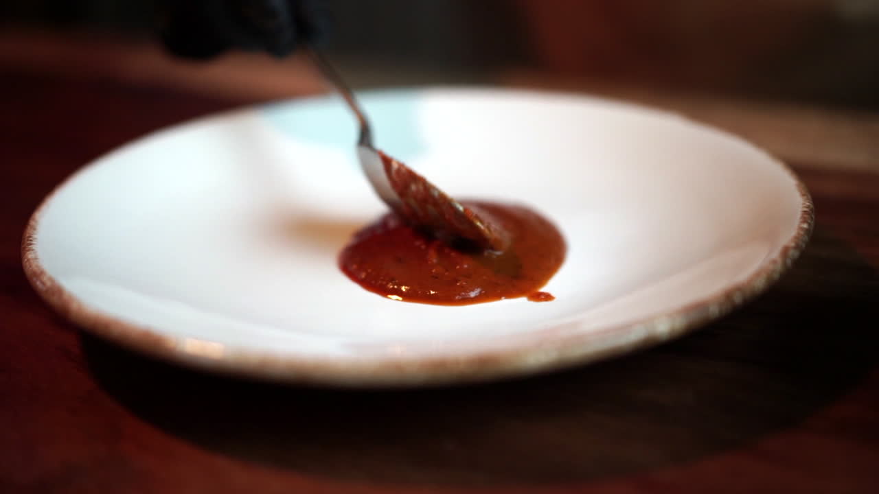 Chef preparing base plate for pasta with tomato sauce slow motion