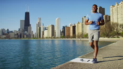 african american male exercising outdoors using smart watch