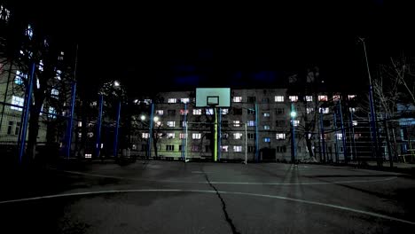 malla de metal. cancha de baloncesto vacía por la noche a la luz de las linternas. deporte callejero. cárcel.