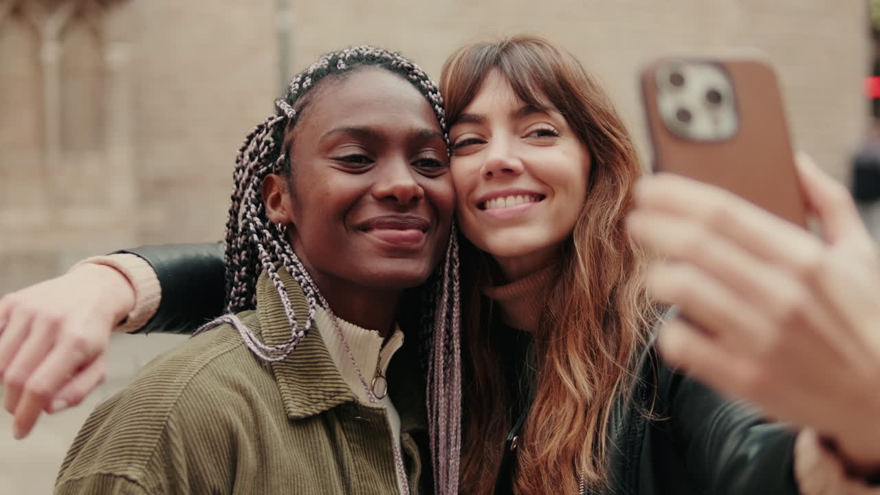 Deux jeunes femmes heureuses prenant un selfie ensemble en plein air