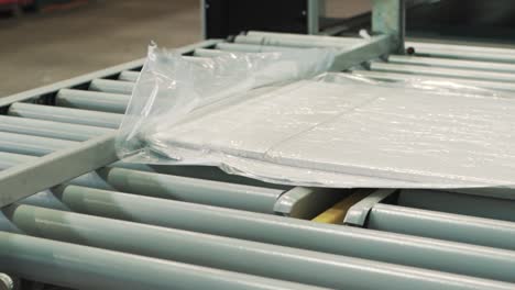 a close-up of a packaging machine with a vacuum press packs textile products in stretch film