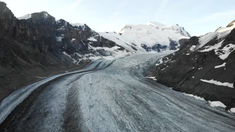 Aerial-flyover-over-Corbassiere-glacier-in-Valais,-Switzerland-at-sunrise