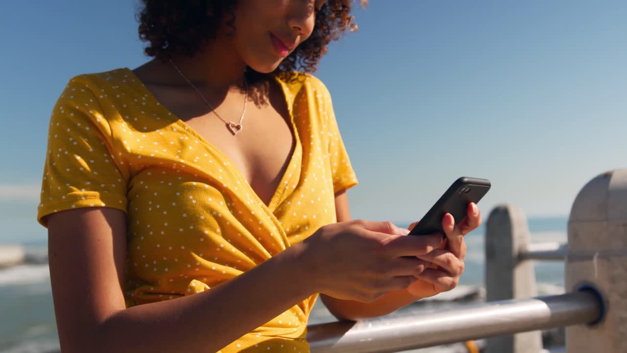 mujer usando el teléfono en la playa