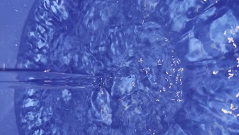 close up view of water filling up blue bucket