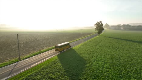 el autobús escolar viaja por una carretera rural en una brillante mañana soleada.