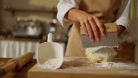 a baker kneading dough in a kitchen