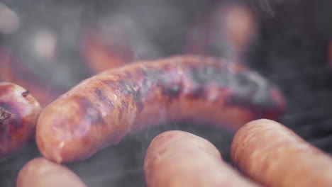 Slow-Motion-Macro-of-Meat-Fork-Flipping-Sizzling-Gristly-Sausage-on-Smokey-BBQ-Grill