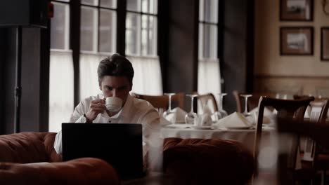 man working on laptop in a cafe