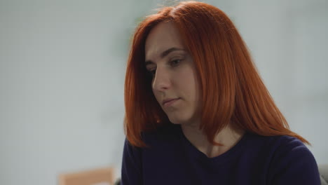 redhead woman takes off glasses after long work on computer