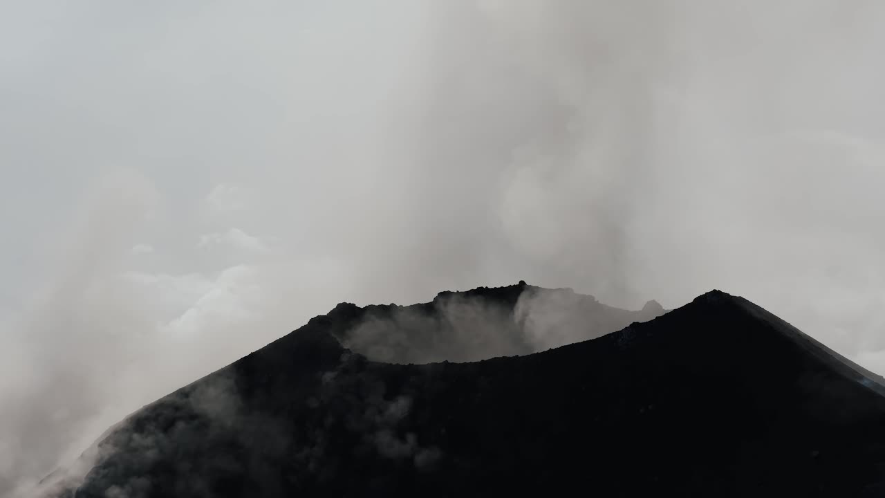 Imagem aérea orbital sobre a cratera do Vulcão de Fogo na Guatemala com cinzas subindo ao céu.