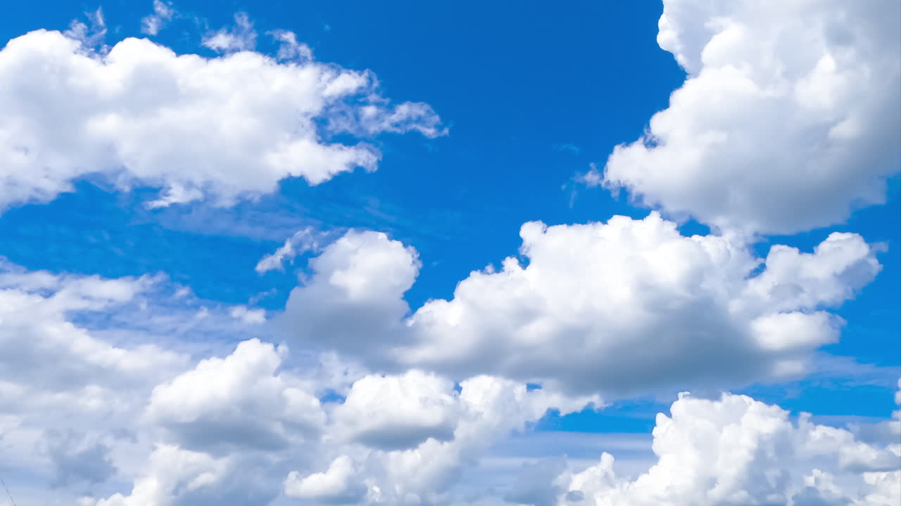 Heavenly beautiful cumulus clouds transforming in the blue skies. Light spindrift clouds at backdrop. Timelapse.