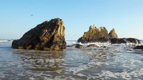 Waves-crashing-on-the-shore-of-El-Matador-Beach-at-golden-hour-in-Malibu,-California