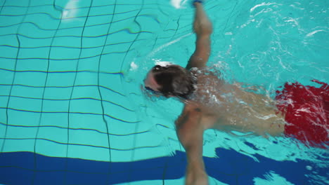 hombre caucásico nadando en la piscina usando la técnica de braza