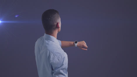 animation of caucasian businessman using smartwatch over glowing light on blue background