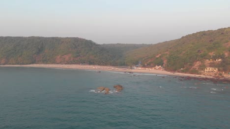 arabian sea washing up on arambol shore in goa, india - aerial wide fly-over shot