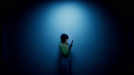 woman using a phone in a brightly lit studio setting.