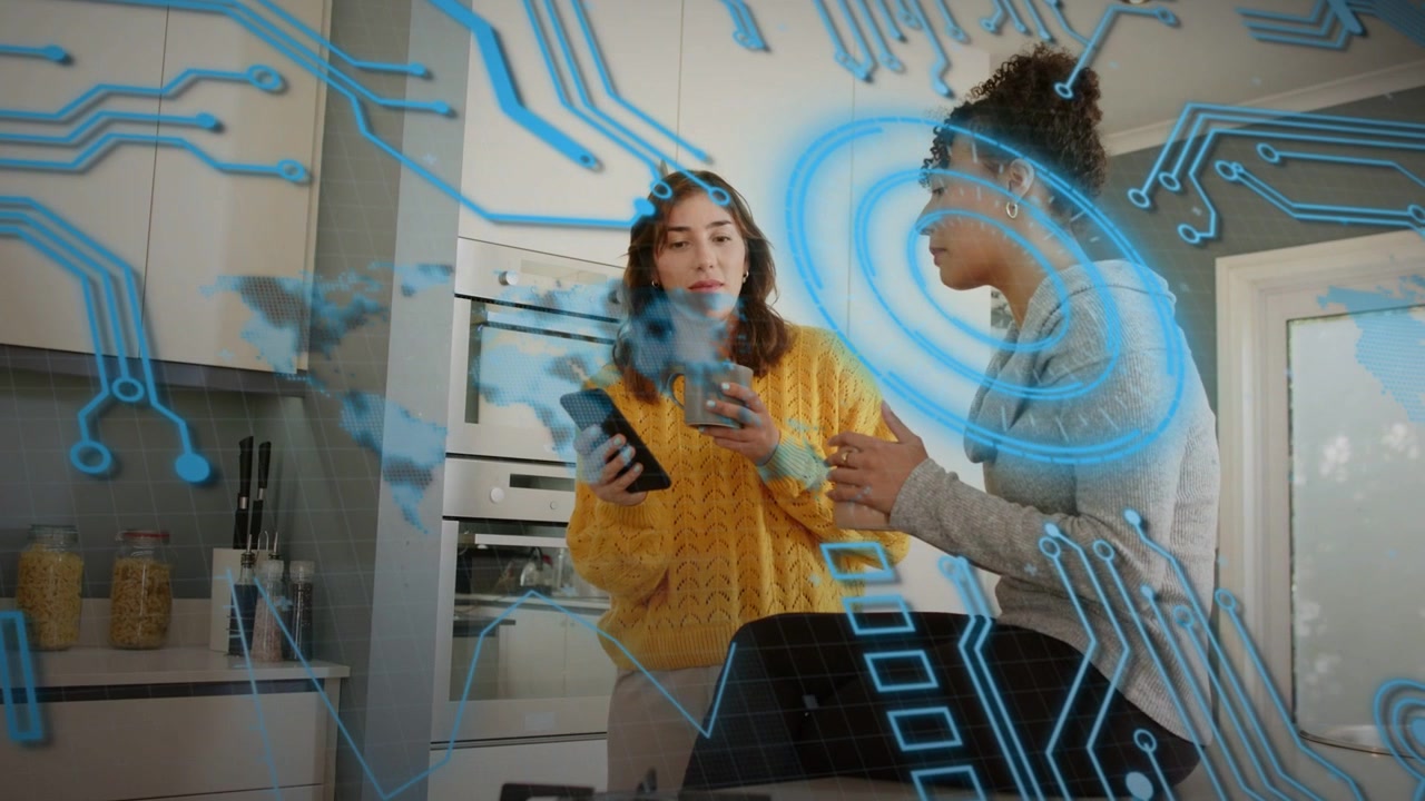 Two women at kitchen island showing phone, activating blue circuit overlay while demoing app