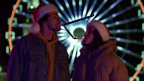 cheerful couple having fun outdoor. pair in santa hats celebrating christmas.