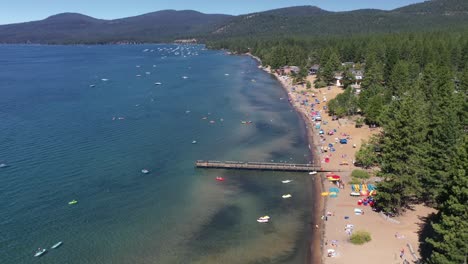 emerald bay beach with tourists on the shore - lake tahoe ca - aerial drone shot