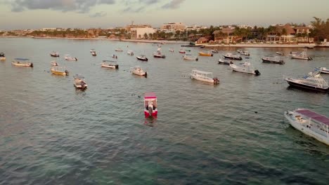 AERIAL---Boats-anchored-at-sunrise-off-the-coast-of-Cancun,-Mexico,-circle-pan