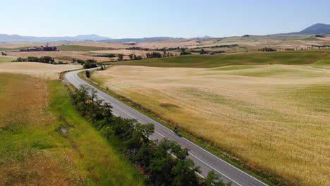 Toma-Aérea-De-Un-Ciclista-En-Las-Colinas-De-Val-D&#39;Orcia,-Toscana,-Italia