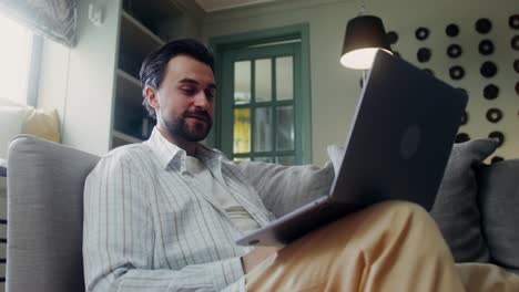 hombre trabajando en una computadora portátil en casa