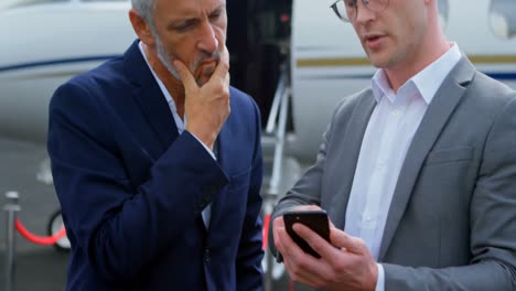 Businessmen-discussing-over-mobile-phone-4k