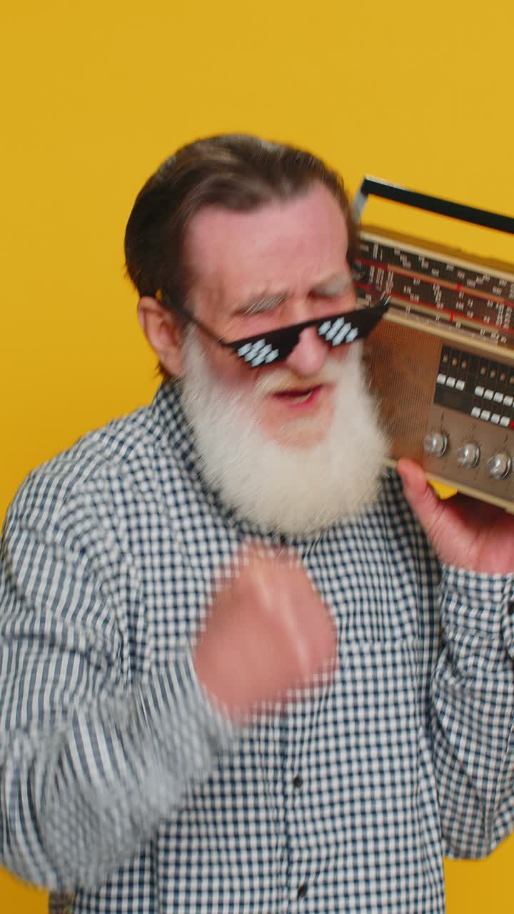 Happy old man listen music on retro tape record player disco dancing fan of vintage technologies