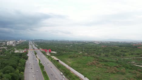 Vista-Panorámica-De-La-Ciudad-De-Islamabad:-Increíble-Toma-De-Drones-De-La-Autopista-De-Cachemira-En-Islamabad,-Capital-De-Pakistán,-Carreteras-Con-Mucho-Tráfico-Y-Puentes-Durante-El-Día