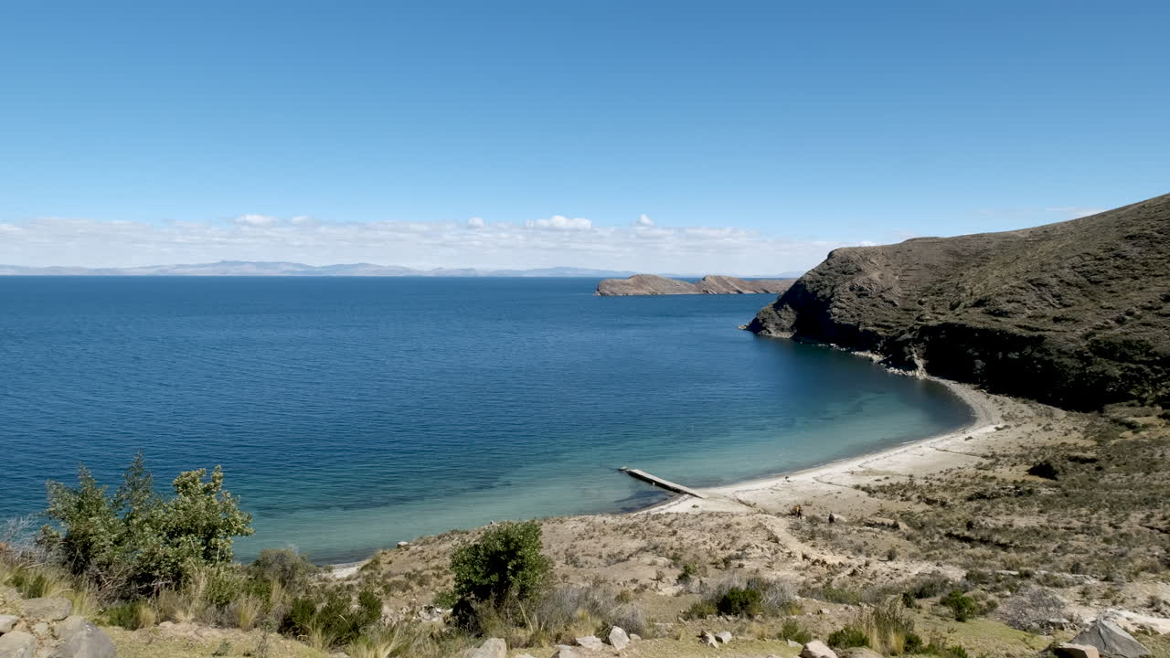 Experience the serene beauty of Las Gemelas Beach on Isla del Sol, Copacabana, Bolivia. Showcases the crystal-clear waters and stunning panoramic views of Lake Titicaca