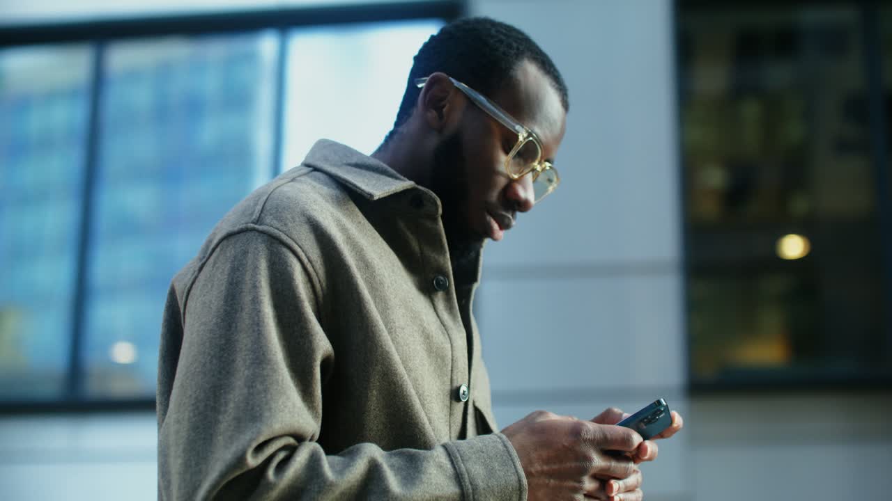 Uomo che scrive messaggi sullo smartphone in città