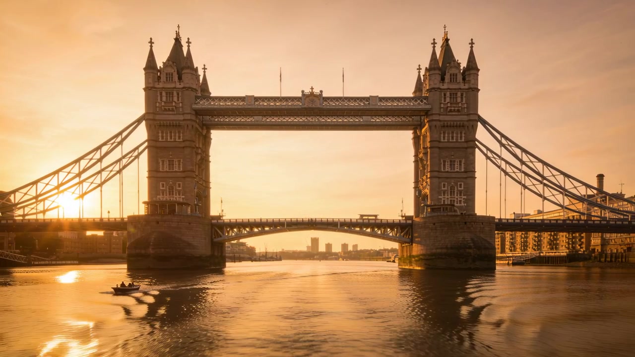 Bateau apparaissant avec deux personnes pour les loisirs, traversant la Tamise sous le Tower Bridge au centre de Londres, laissant un sillage.