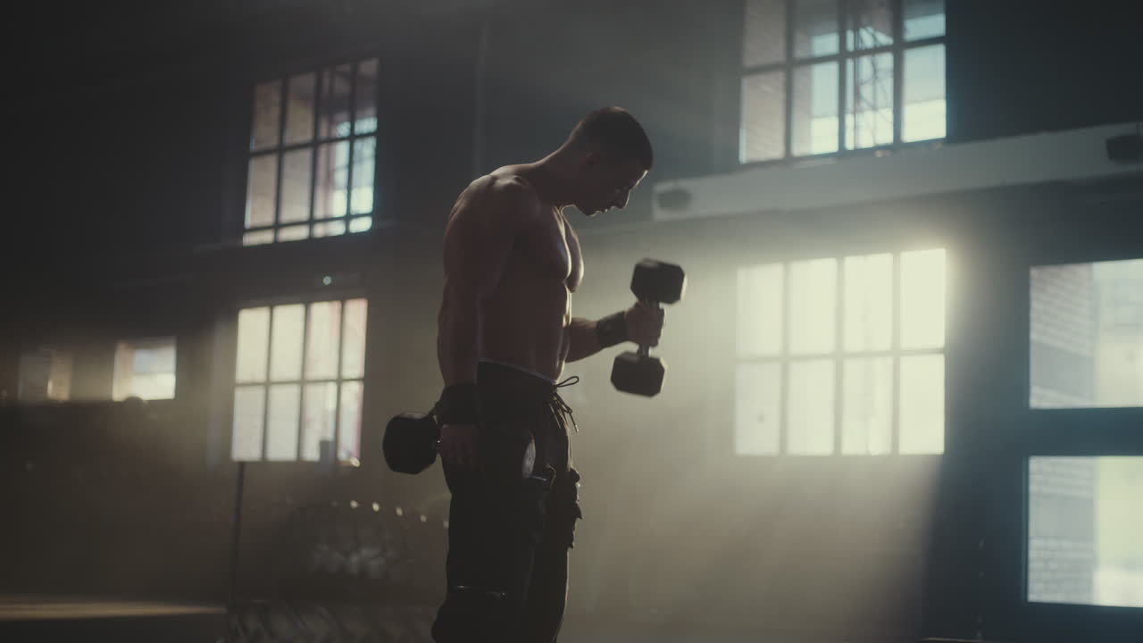 Man Working Out with Dumbbells in a Gym